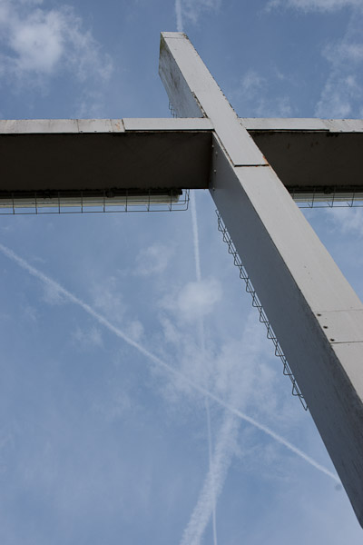 metal cross with vapour trails